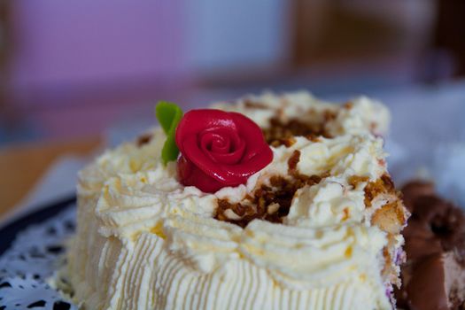 Cream cake with red flower on top