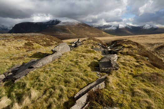 A view of the mountain Mynydd Mawr and the Nantlle Ridge, Snowdonia National Park, Wales, UK, with snow covered tops on a cloudy day.