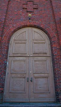 Wooden church door and red tile wall