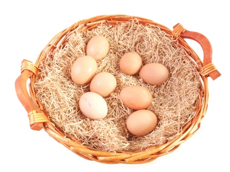 Eggs in a wicker basket with straw - isolated over white