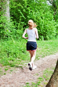 young woman is jogging in forest