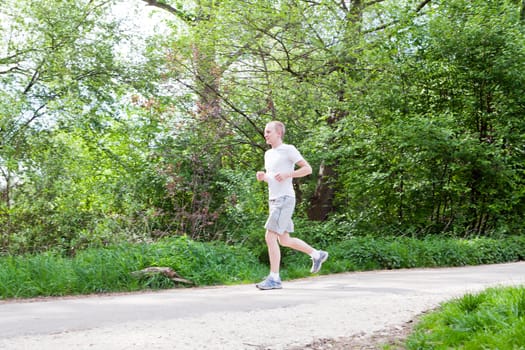 man is jogging in the forest