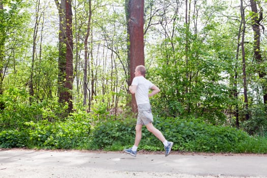 man is jogging in the forest