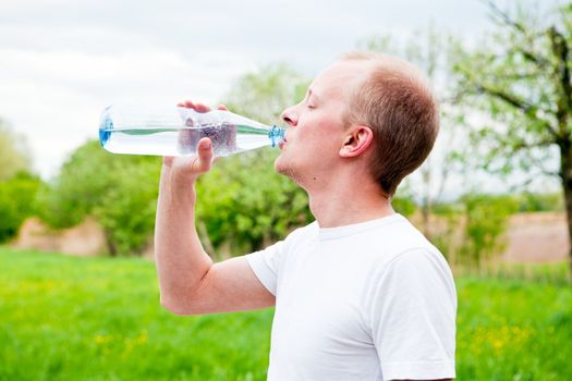 young jogger is drinking water outdoor