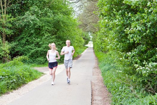 young couple is jogging in the forest