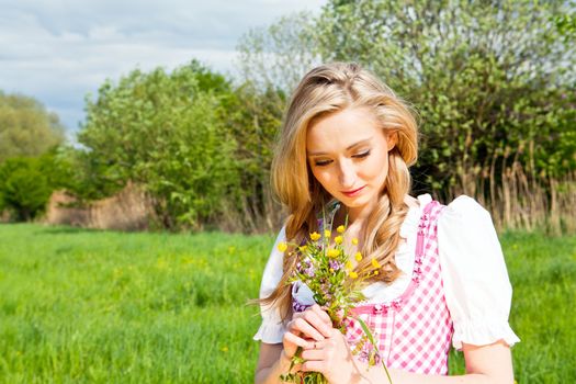 young woman with pink dirndl outdoor in summer