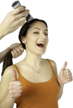 Hairdresser buzzing long hair of happy female model with thumbs up