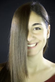 woman with long brunette straight hair in front of her face