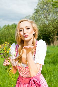 young woman with pink dirndl outdoor in summer