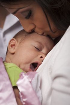 Young Attractive Ethnic Woman Holding Her Yawning Newborn Baby.