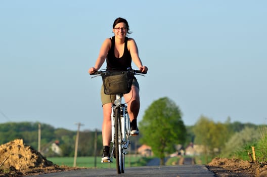 The picture shows a young woman in a new cycle path at the time of leisure.