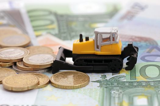 tractor rakng coins on euro banknotes