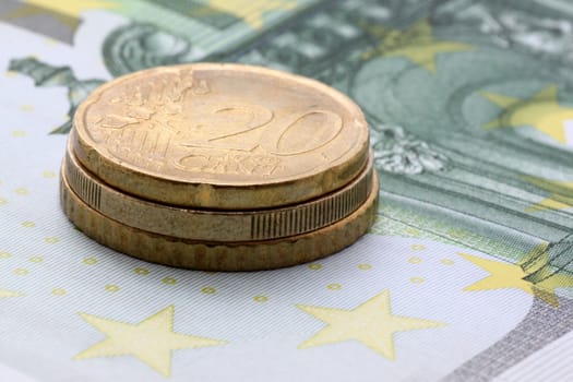 close up of pile of euro coins on one hundred euro banknote