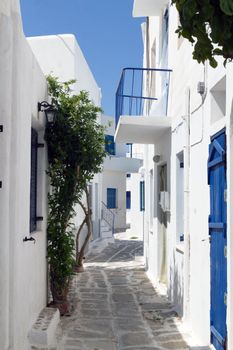 Classical narrow street with a painted sidewalk in Parikia