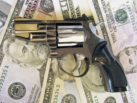 gun on heap  of dollars