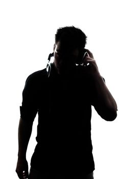 Male in silhouette listening to headphones isolated on white background