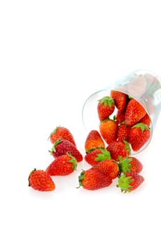 strawberry spilling out of glass   on white background