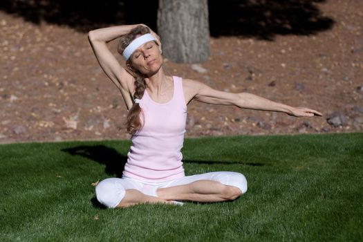 mature women exercising on grass in park