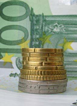 pile of coins on one hundred euro banknote