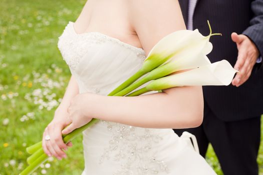 Cropped image of bride hands holding white calla lilies