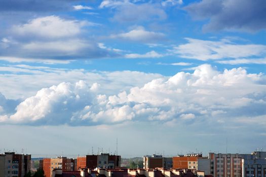top view on the city roofs under the blue sky with clouds