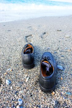 pair of businessman shoes on the beach