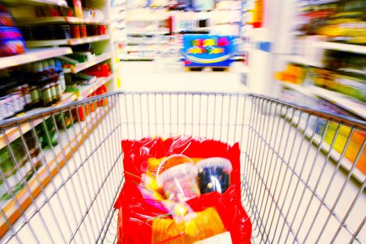 shopping cart standing between shelves in the supermarket