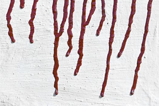 streaks of red paint on the whitewashed wall in the background