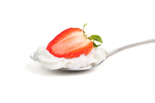 a half strawberry in whipped cream on an spoon