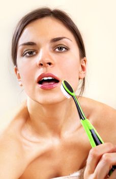 beautiful woman with tooth-brush cleans her teeth