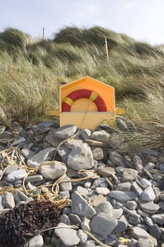 lifebuoy on rocky beal beach in county Kerry Ireland with dunes in background