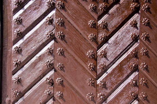 Background of ancient retro wooden door. Brown painted decorated old style door.