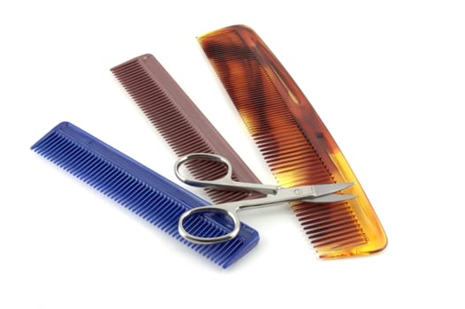Combs and scissors over white