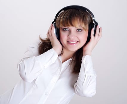 portrait of a beautiful woman in a white blouse, listening to music and happy