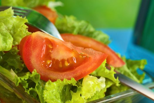 Fresh salad of lettuce and tomato (Selective Focus, Focus on the seeds of the tomato slice in the front) 