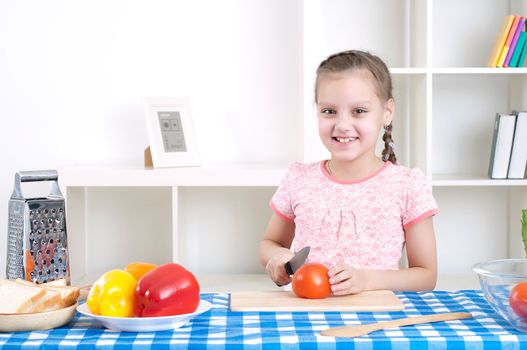 beautiful young girl cooking vegetables for a salad, working in kitchen