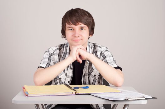 student in exams, sits at the table and reading a book