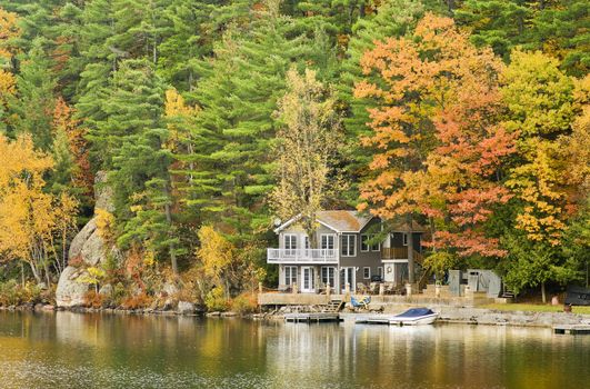 A beautiful 2-storey cottage on the lake during Autumn.