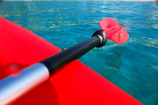 close-up of a red paddle outside in the ocean