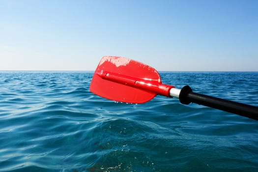 close-up of a red paddle outside in the ocean