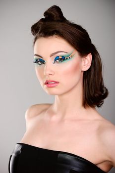 young beautiful woman with makeup in black dress studio shot