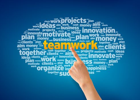 Hand pointing at a Teamwork Word Cloudon blue background.