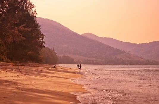 a couple walk along this tropical island beach