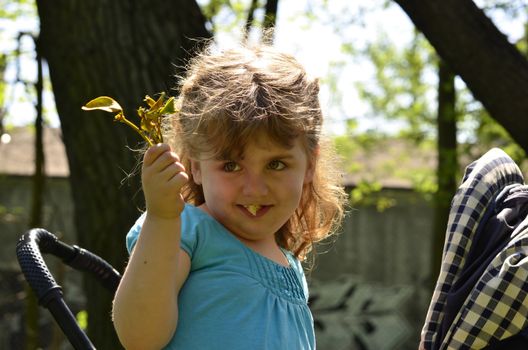 The picture shows a little girl eating pocorn with bouquet of mistletoe in his hand.