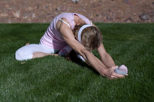 mature women exercising on grass in park