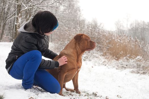 Funky boy is having fun with his dog in the snow