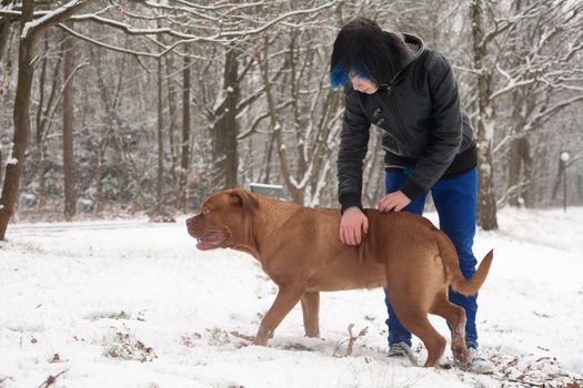 Funky boy is having fun with his dog in the snow