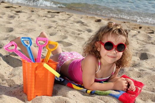 little girl with sunglasses on the beach