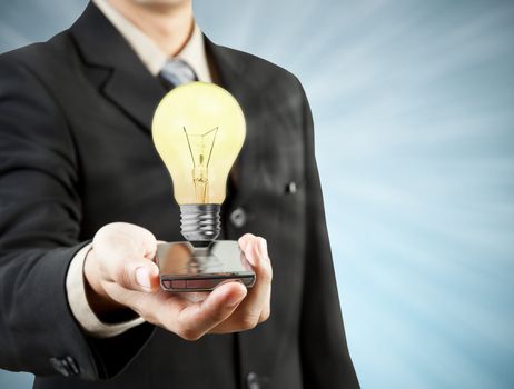 Businessman holding mobile phone light bulb coming out  technology, and new ideas concept