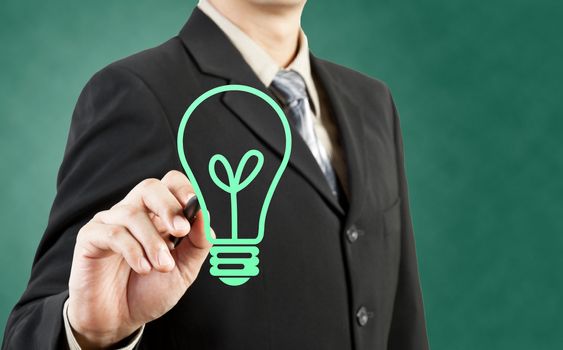 Businessman drawing light bulb green concept